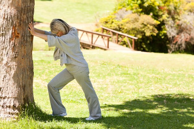 Mujer madura haciendo sus streches en el parque