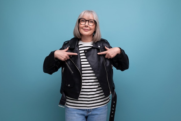 La mujer madura de negocios de mediana edad con cabello gris en un elegante look juvenil se ve genial en un azul