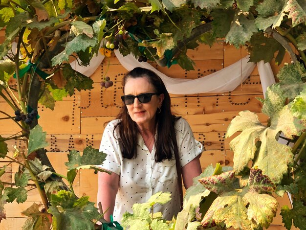 Foto mujer madura de pie en medio de las plantas