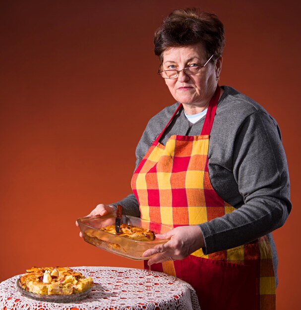 Mujer madura preparando tarta de manzana