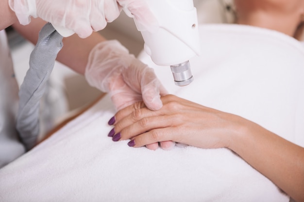 Mujer madura recibiendo tratamiento de cuidado de la piel en el salón de belleza