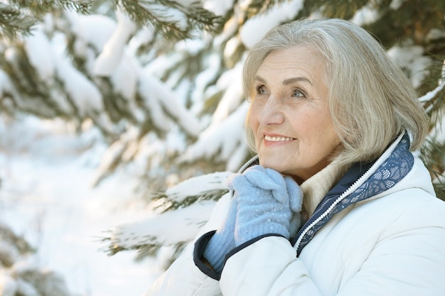 Mujer madura en ropa de invierno posando al aire libre, de buen humor