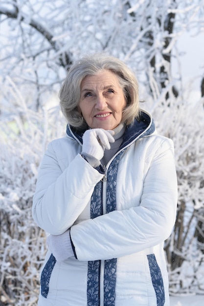 Mujer madura en ropa de invierno posando al aire libre, de buen humor