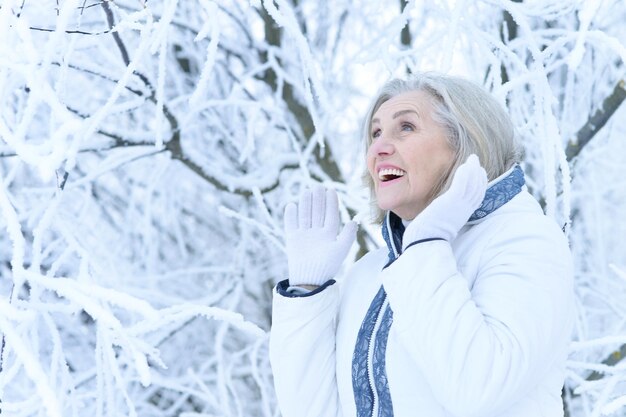 Mujer madura en ropa de invierno posando al aire libre de buen humor