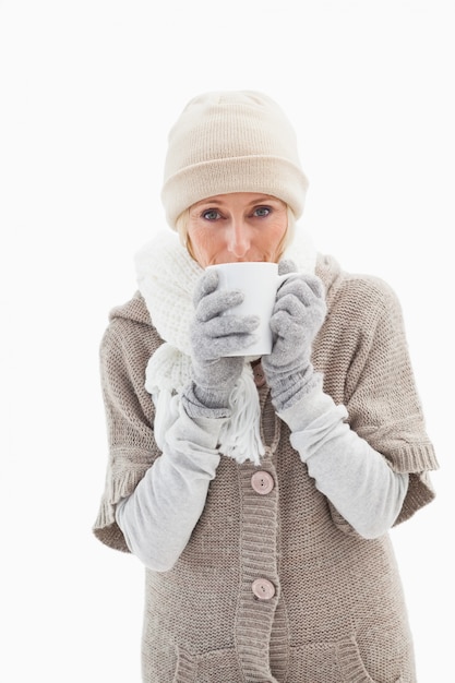 Mujer madura en ropa de invierno sosteniendo la taza