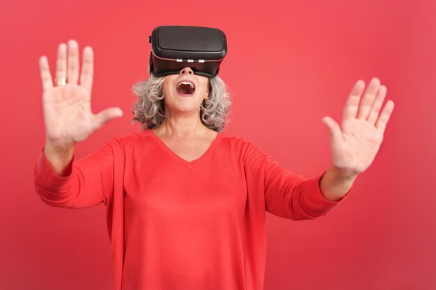 Mujer madura sorprendida usando gafas de realidad virtual