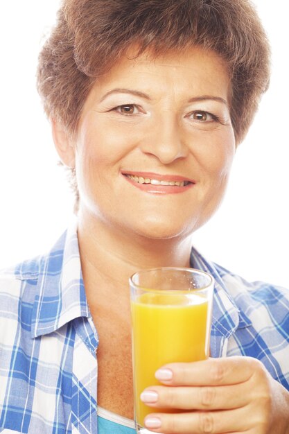 Foto mujer madura sosteniendo un vaso de jugo de naranja