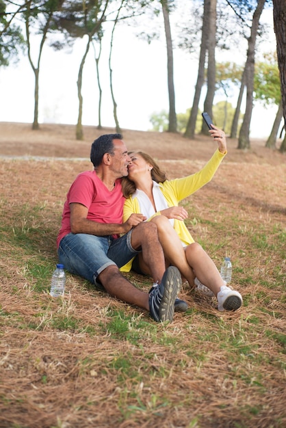 Mujer madura, toma, selfie, besar, con, marido