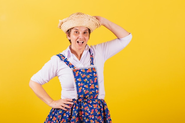 mujer madura, vestido, en, típico, festa junina, ropa, tenencia, sombrero de paja