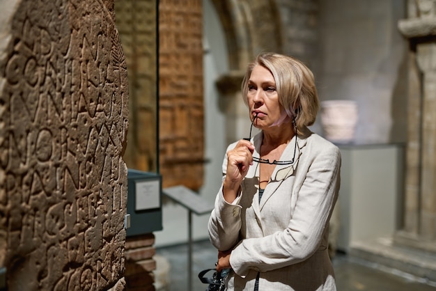 Mujer madura visitando museo de antigüedades