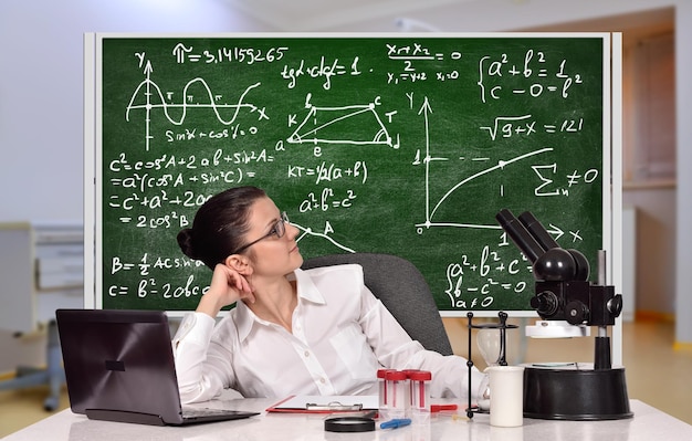 Mujer maestra sentada en laboratorio