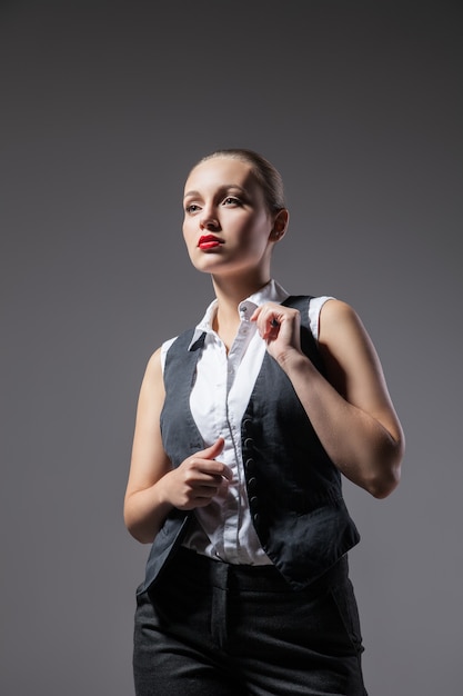 Mujer mafiosa sobre fondo gris oscuro. Foto de moda. Estilo retro