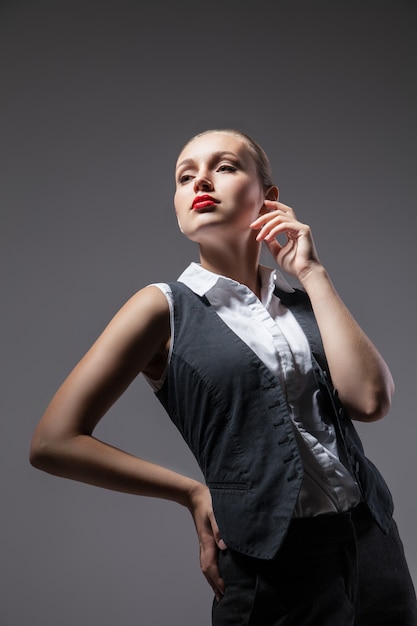 Mujer mafiosa sobre fondo gris oscuro. Foto de moda. Estilo retro