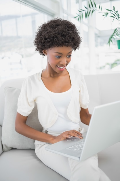 Mujer magnífica enfocada que usa la computadora portátil