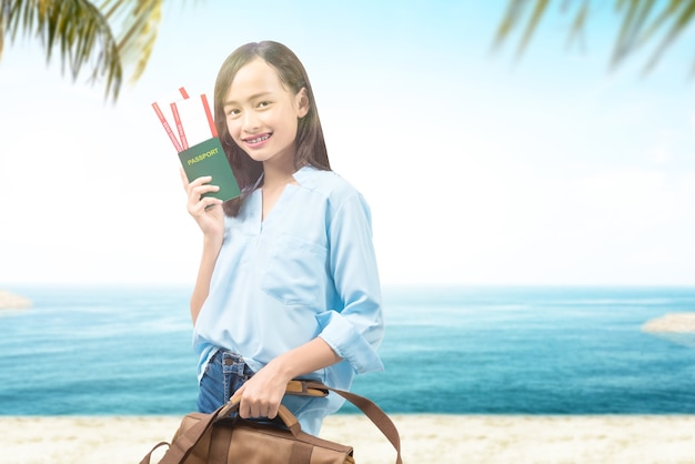 Mujer con una maleta con billete y pasaporte en la playa