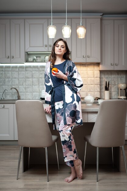 Mujer de la mañana en la cocina. Comida sana