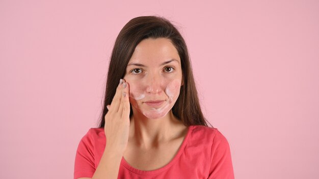 Mujer mancha su rostro con crema para el acné