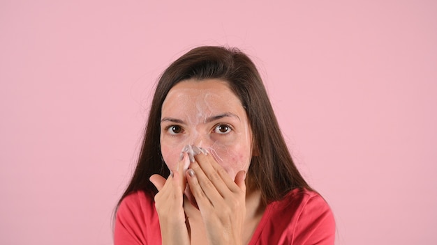 Mujer mancha su rostro con crema para el acné