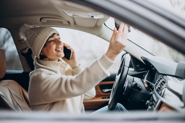 Mujer manejando en auto y usando teléfono