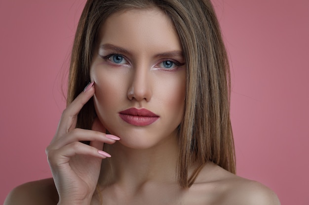 Mujer con manicura sobre fondo rosa