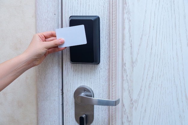 Mujer mano abriendo la puerta del hotel con tarjeta