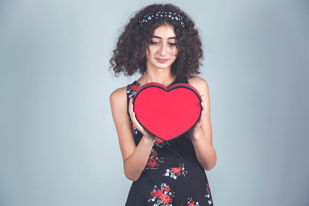 Mujer mano corazón rojo