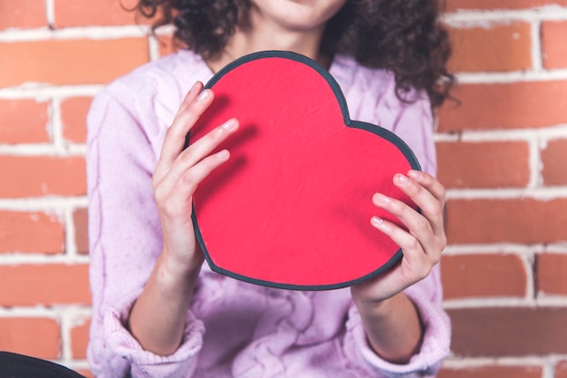 Foto mujer mano corazón rojo