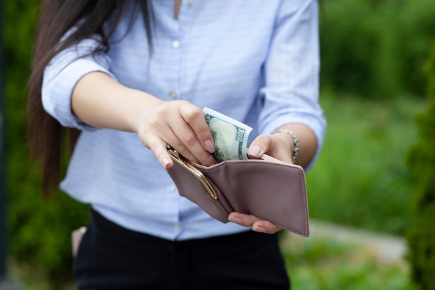 Mujer mano dinero en billetera en la calle