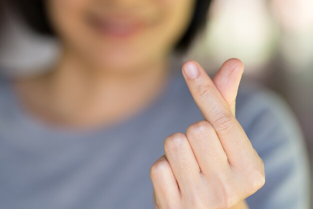 Una mujer de la mano está haciendo un signo de corazón