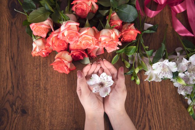 Mujer mano flores en la mesa