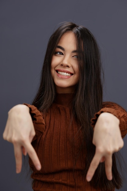 Mujer mano gestos suéter marrón moda fondo gris