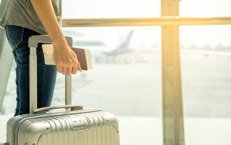 Mujer de mano con pasaporte billete de embarque con equipaje de tranvía en el aeropuerto Concepto de viajero