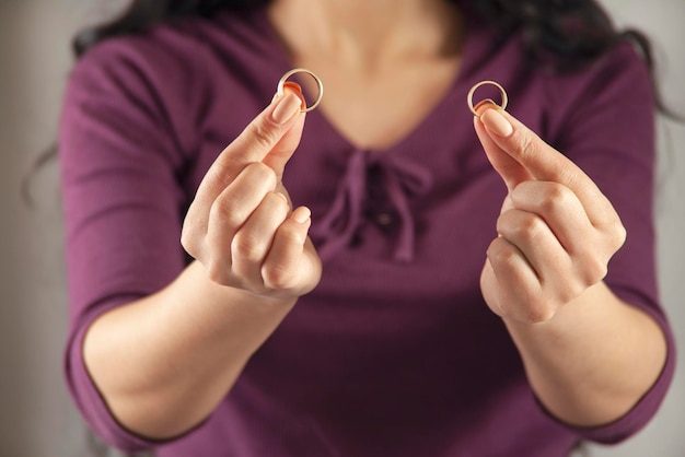 Mujer mano sosteniendo anillo de mujer y hombre