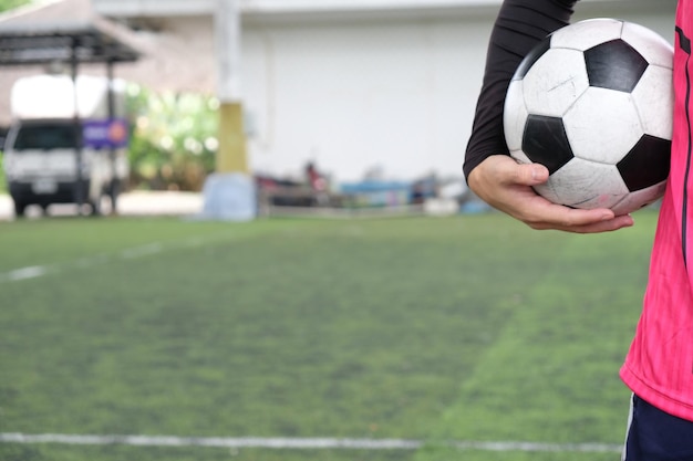 Foto mujer con la mano sosteniendo la pelota en el campo