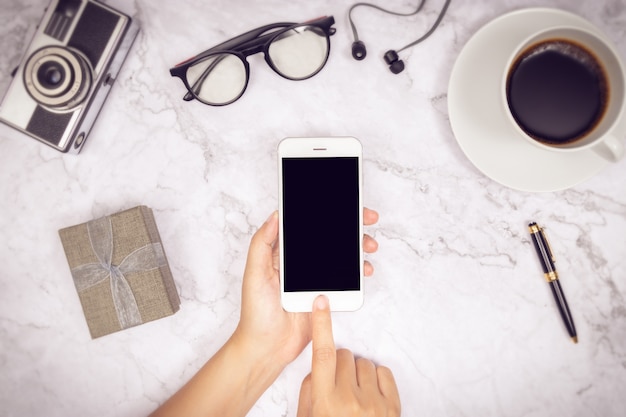 Foto mujer mano uso maqueta de teléfono móvil en blanco pantalla negra con dedo en pantalla táctil