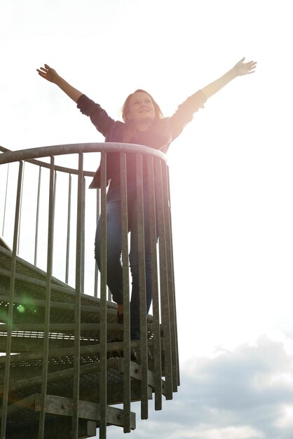 Foto mujer con las manos levantadas hacia el cielo