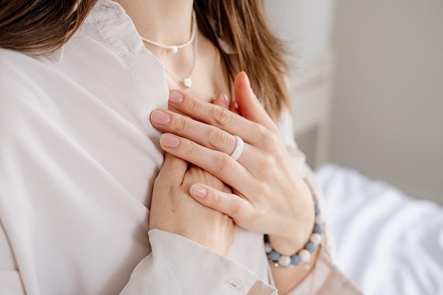 Mujer con las manos sobre el corazón disfrutando de la respiración con los ojos cerrados concepto de estilo de vida saludable