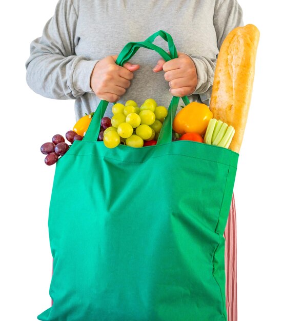 Mujer mantenga la bolsa de compras llena de frutas y verduras frescas aisladas sobre fondo blanco.