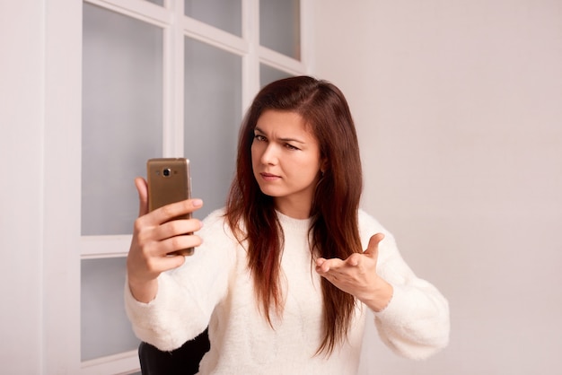 Mujer mantenga teléfono móvil hablando discutiendo problemas centrados chica con smartphone