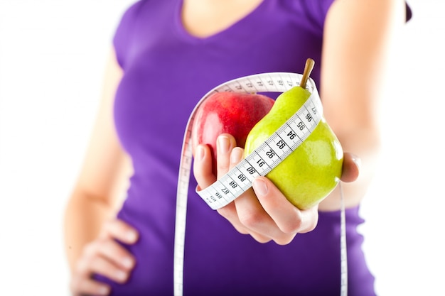 Mujer con manzana, pera y cinta métrica