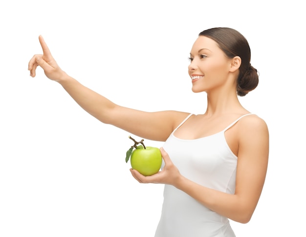 mujer con manzana verde apuntando con su dedo a algo.