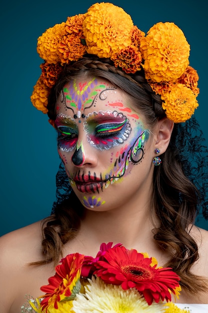 Mujer con maquillaje de Catrina y flores en el cabellos usando un vestido blanco Dia de Muertos