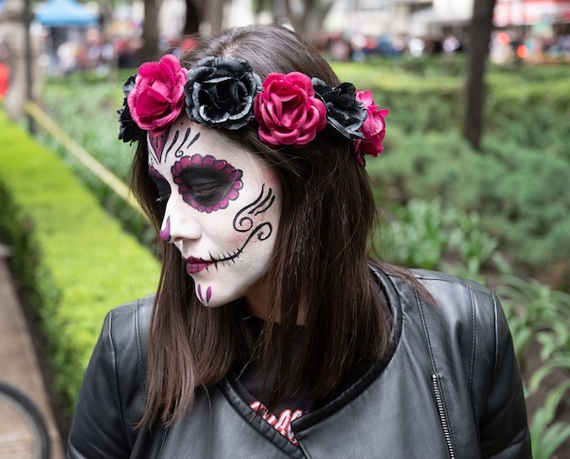 Mujer con maquillaje de catrina con una tiara de rosas en el tradicional día de muertos en la ciudad de México