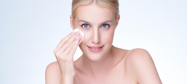 Mujer de maquillaje natural agradable primer plano usando soplo de polvo para maquillaje facial