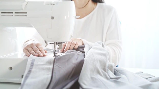 Una mujer con máquina de coser blanca atelier estudio de costura