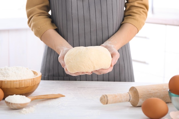 Mujer con masa cruda en la cocina