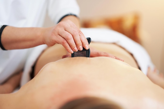 Mujer con un masaje gua sha en el salón