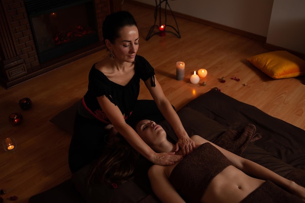 Una mujer masajea a una mujer en una habitación con chimenea y chimenea.