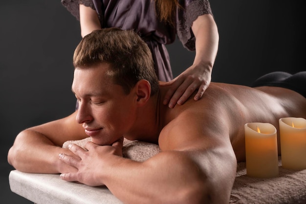 mujer masajeando la espalda de un cliente masculino