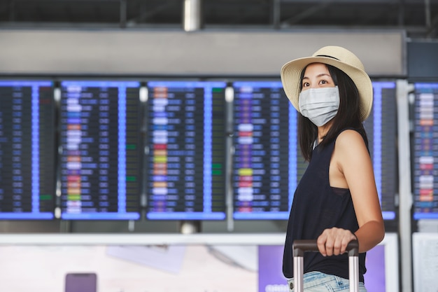 Mujer con máscara caminando en el aeropuerto